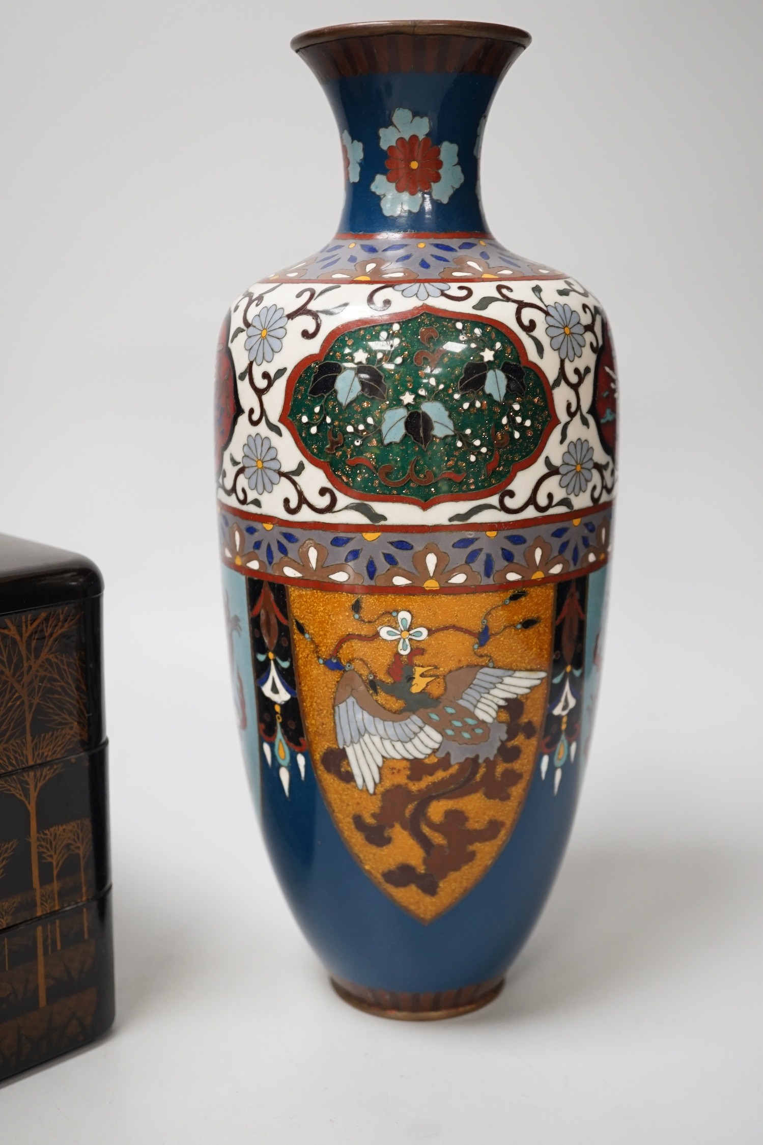 A large Japanese cloisonné enamel vase, 30.5cm high, a similar jar and cover and a Japanese lacquered tiered box with 3-4 drawers. Tree design in gold lacquer.